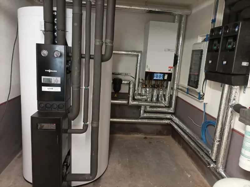 Heizzentrale im Technikraum: Leitungen und Armaturen der Anbindung an das bestehende Heizsystem.