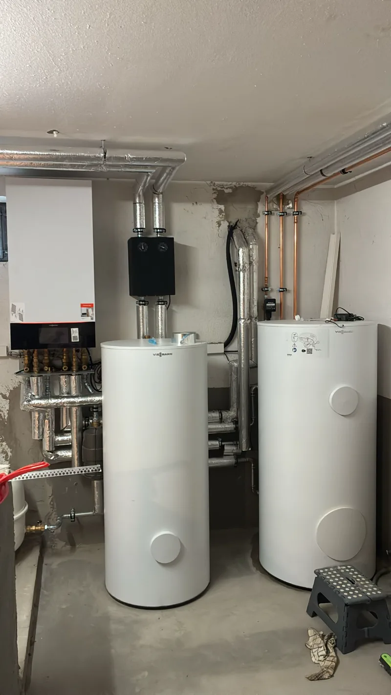 Pufferspeicher im Technikraum, angeschlossen an die Heizungsleitungen.